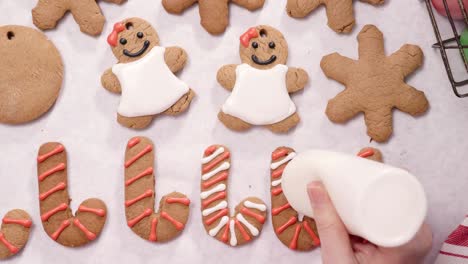 decorating gingerbread cookies with royal icing for christmas.