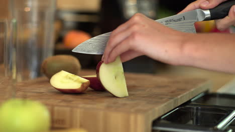 close up of female hands cutting red apple