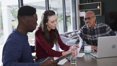 Happy-diverse-couple-and-financial-advisor-using-laptop,tablet-and-documents-at-home,slow-motion