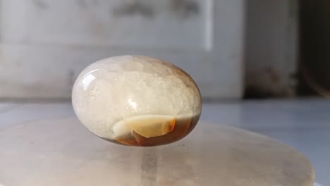 souvenirs made of beautiful stone with a egg shape are rotated in a display case