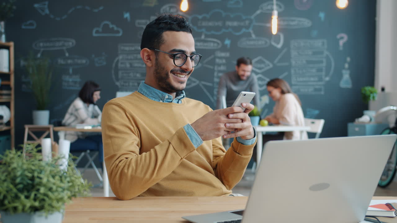 Uomo che usa lo smartphone in un ufficio moderno
