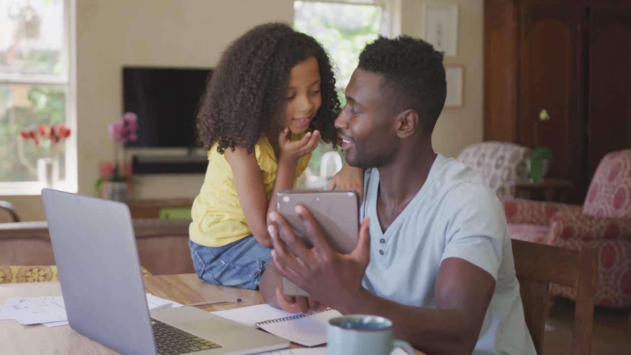 African american father and daughter looking a digital tablet