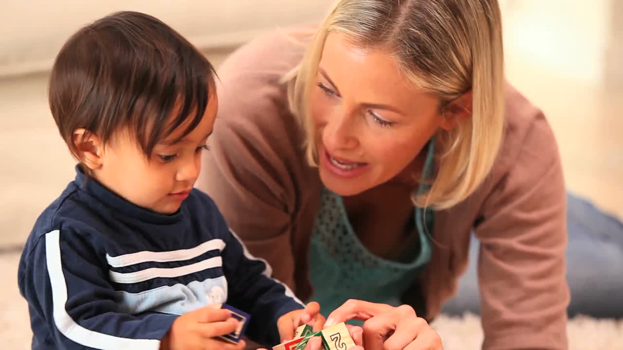 bebé descubriendo bloques gracias a su madre