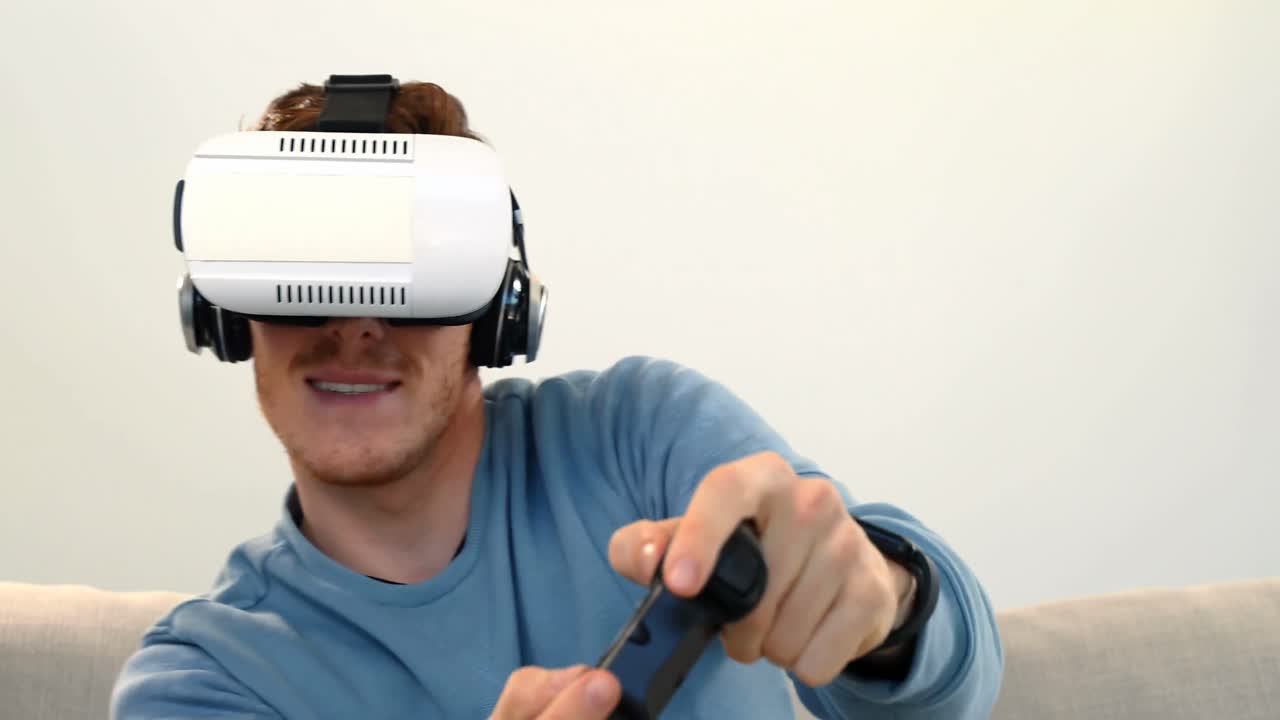 hombre jugando un juego de joystick con auriculares de realidad virtual en el sofá 4k
