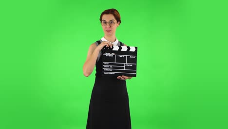 mujer con clapperboard en la pantalla verde