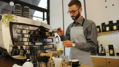 caucasian male barista working in modern coffee shop