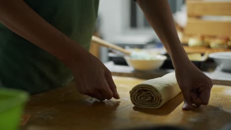 raw and uncooked cinnamon roll dough measured and cut using kitchen thread on wooden table top, filmed as close up slow motion shot