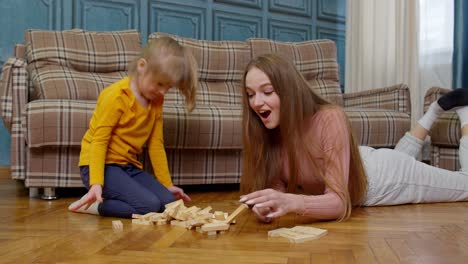 Madre-Juega-Bloques-De-Madera-Juego-De-Mesa-Con-Hija-Pequeña-Niña-En-Casa,-Pasatiempos-De-Ocio