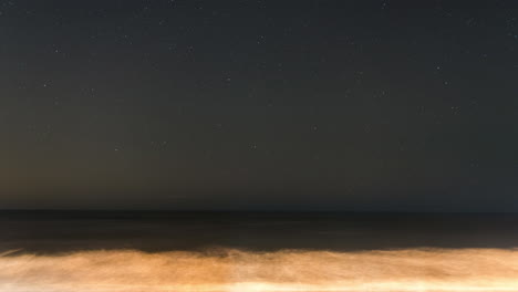 Timelapse-of-a-beautiful-stars-rotating-across-the-night-sky-above-a-scenic-beach