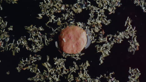 pink food item in a bed of herbs