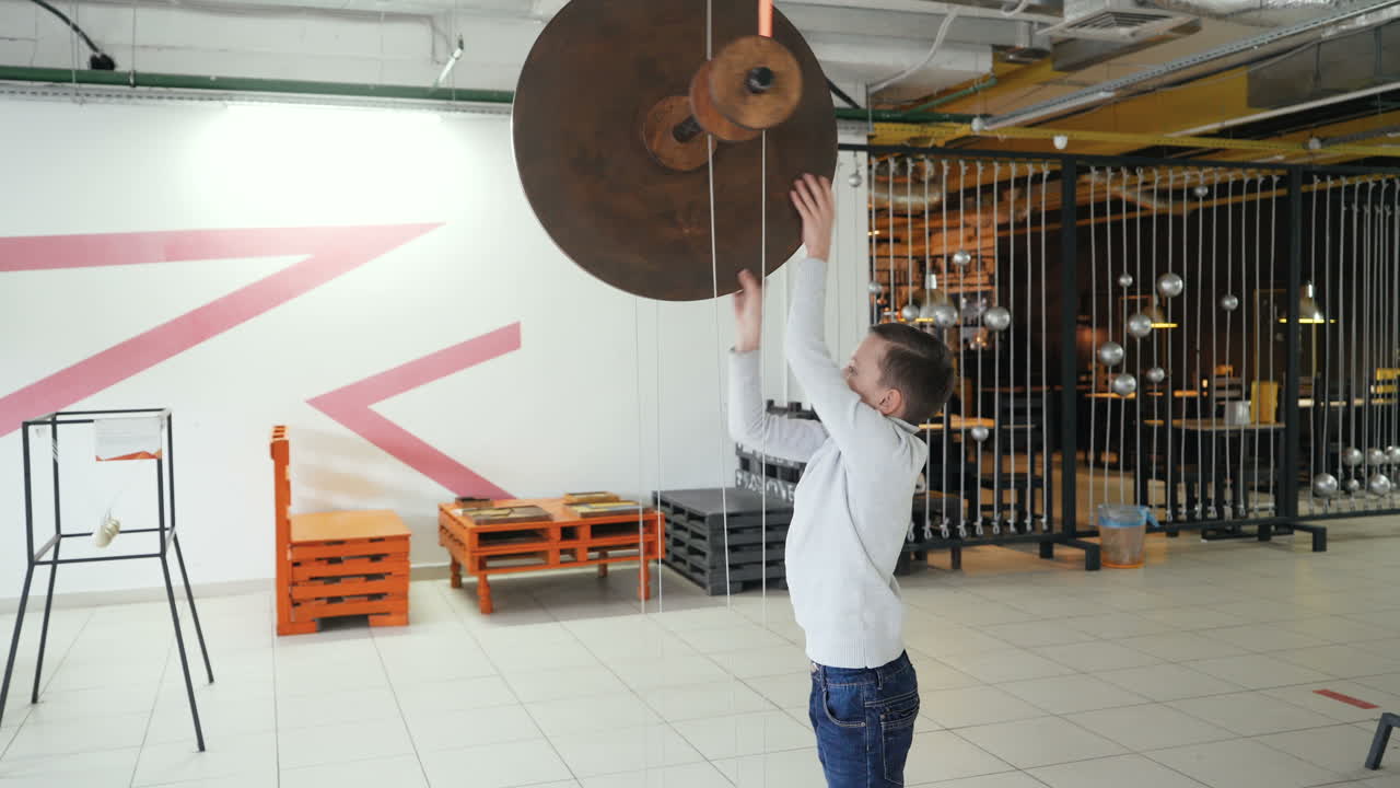 Mechanical conservation of energy. Maxwell's wheel. Boy conducts research experience.