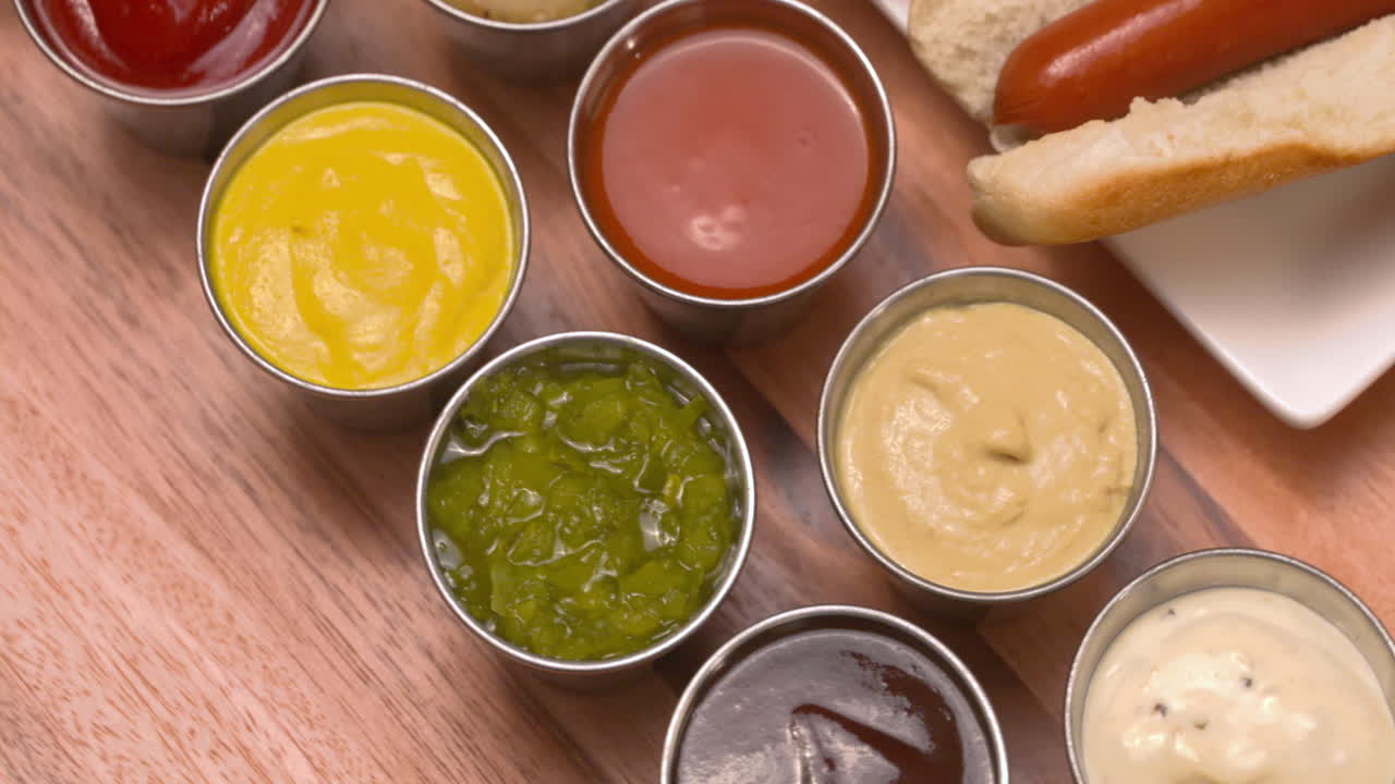 Orbit around a plate of juicy hot dogs with an assortment of condiments on the side