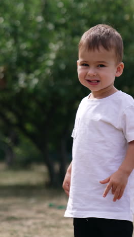 baby boy playing in the park. playing outdoor in park small child. vertical video