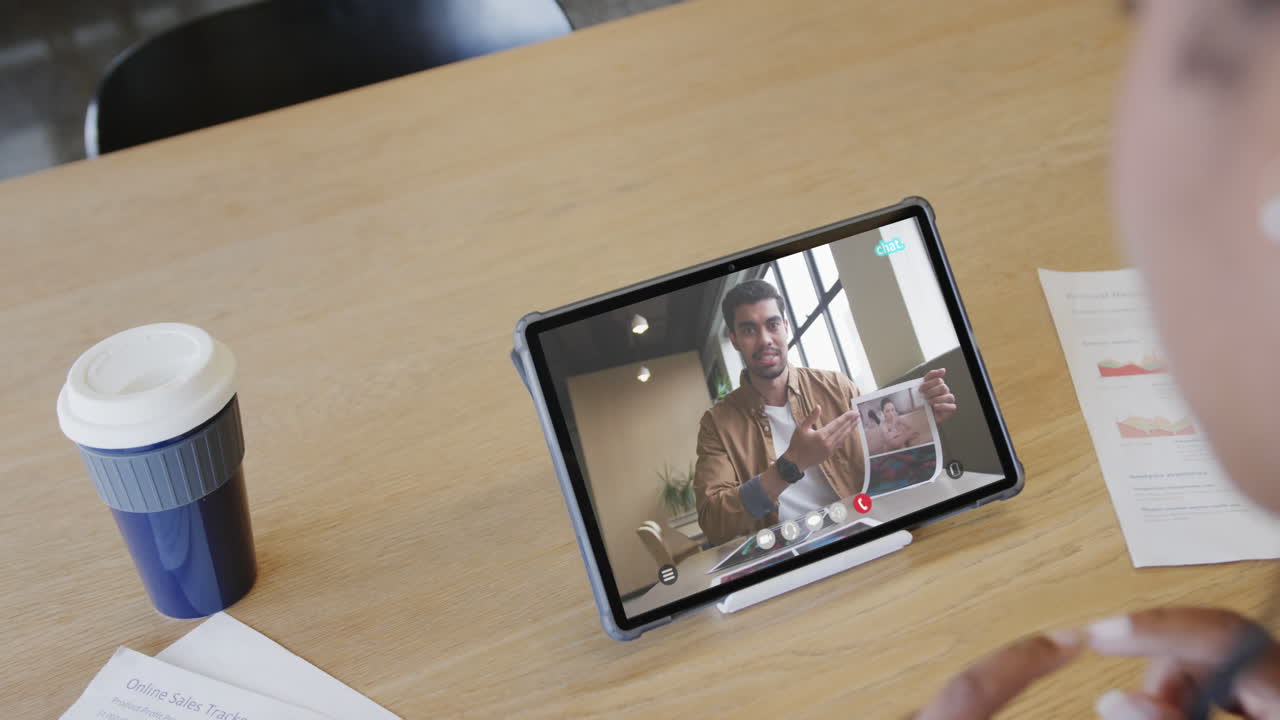 mujer de negocios caucásica en una videollamada con un colega afroamericano en la pantalla