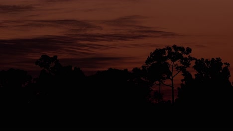 Sunset-revealing-this-fantastic-warm-colors-reflected-on-the-sky-and-clouds-moving-to-the-right-until-dark,-Khao-Yai-National-Park,-Thailand