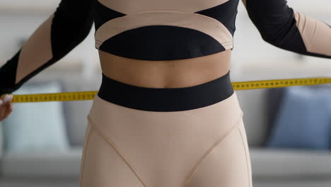 woman measuring waist with tape measure