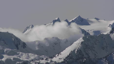a time lapse shot of clouds over a snowy mountain