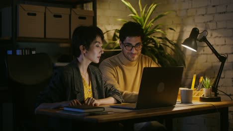 couple working late on laptop in home office