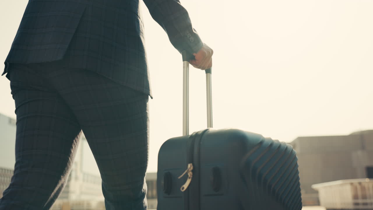 Espalda, mano y maleta de viaje de una persona caminando