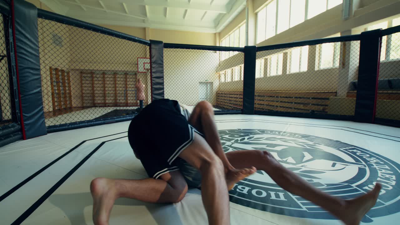 Two men wrestling in a cage