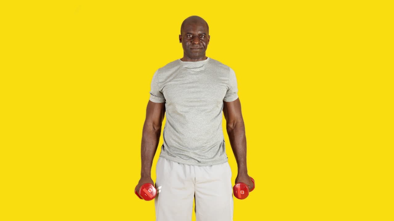 Man exercising with dumbbells on a yellow background