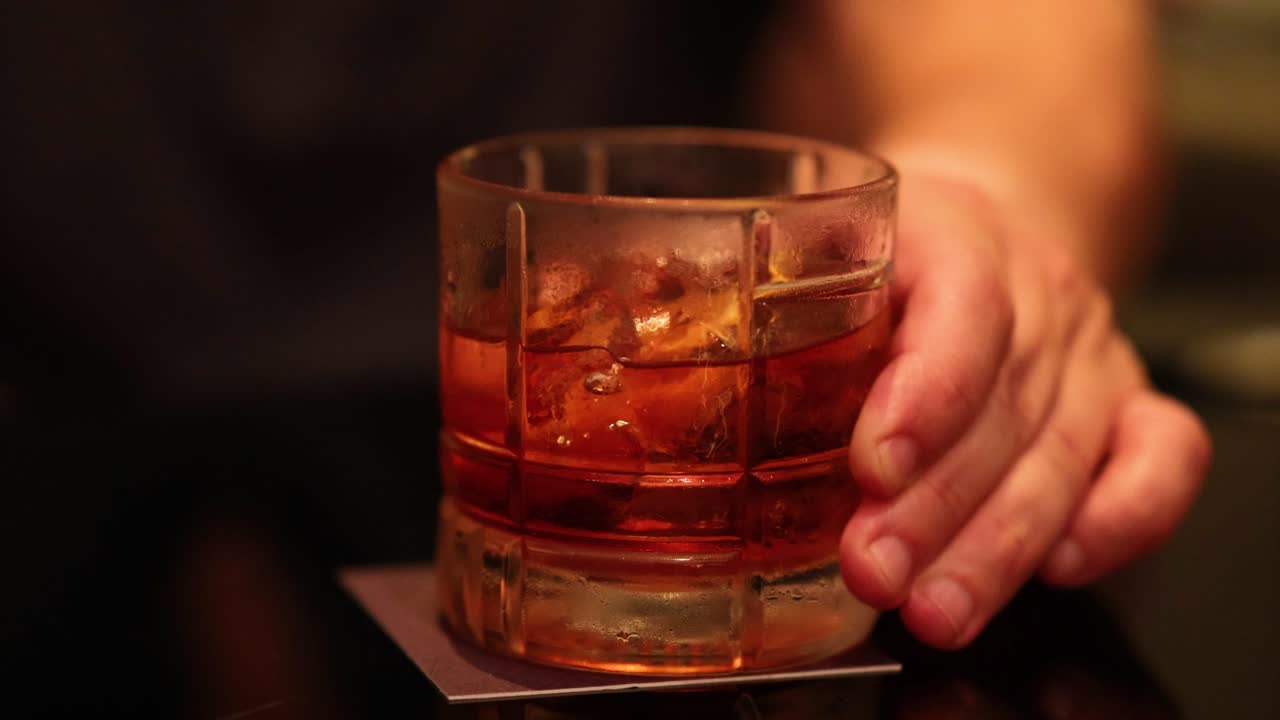 방 에서 네그로니 테일을 들고 있는 손