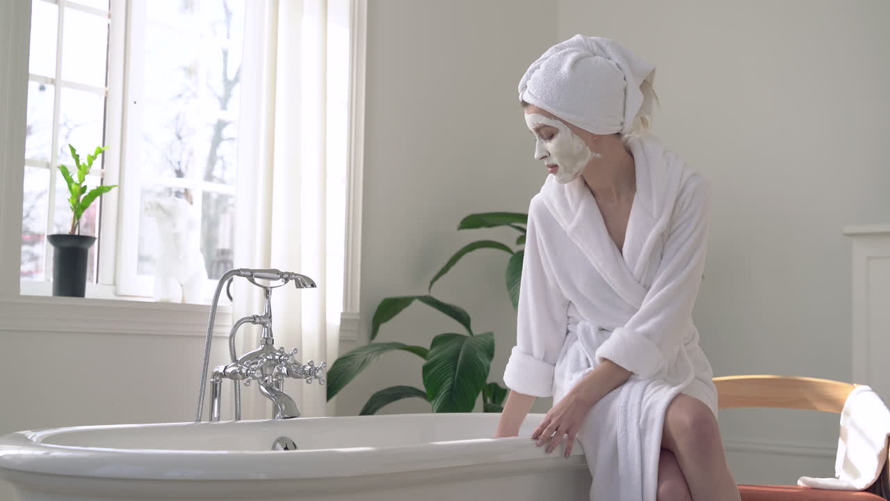 편안한 목욕을 준비하는 얼굴 마스크를 쓴 여자