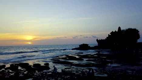 rocket shot from bali beach over tanah lot temple during golden hour - aerial rocket up shot