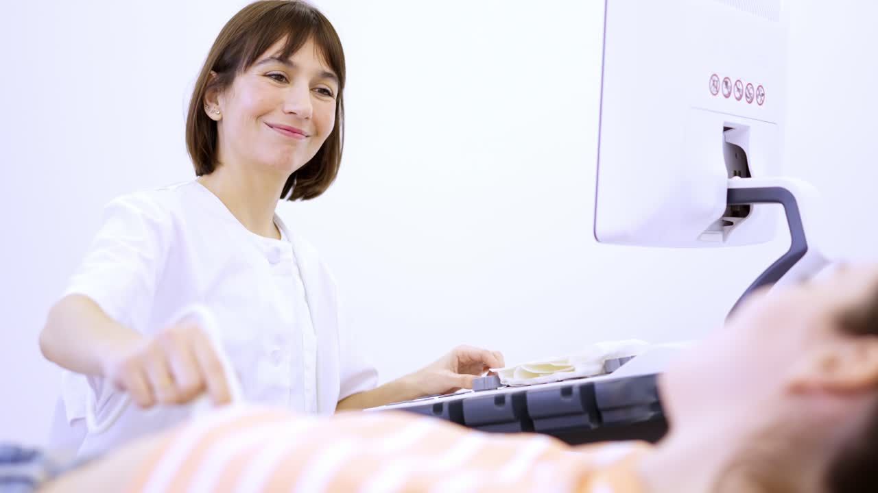 Cheerful female doctor smile during a ultrasound to pregnant woman