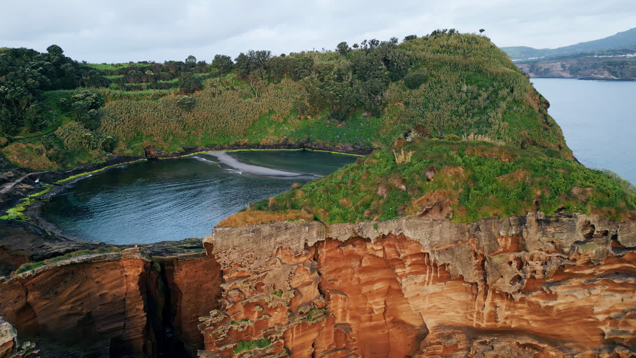 Drone green island lagoon cliff view. Rocky coastline with green lush vegetation