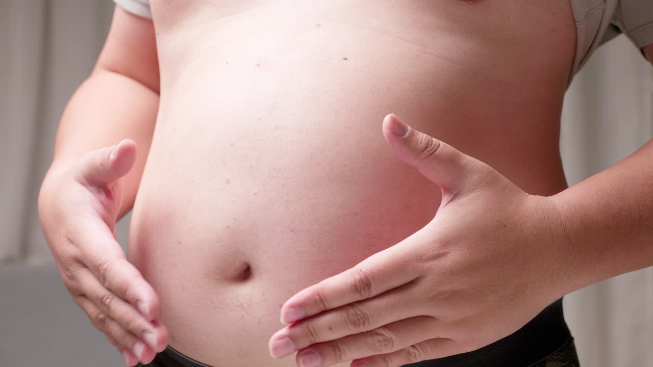 Uomo con la pancia che si preoccupa del suo corpo