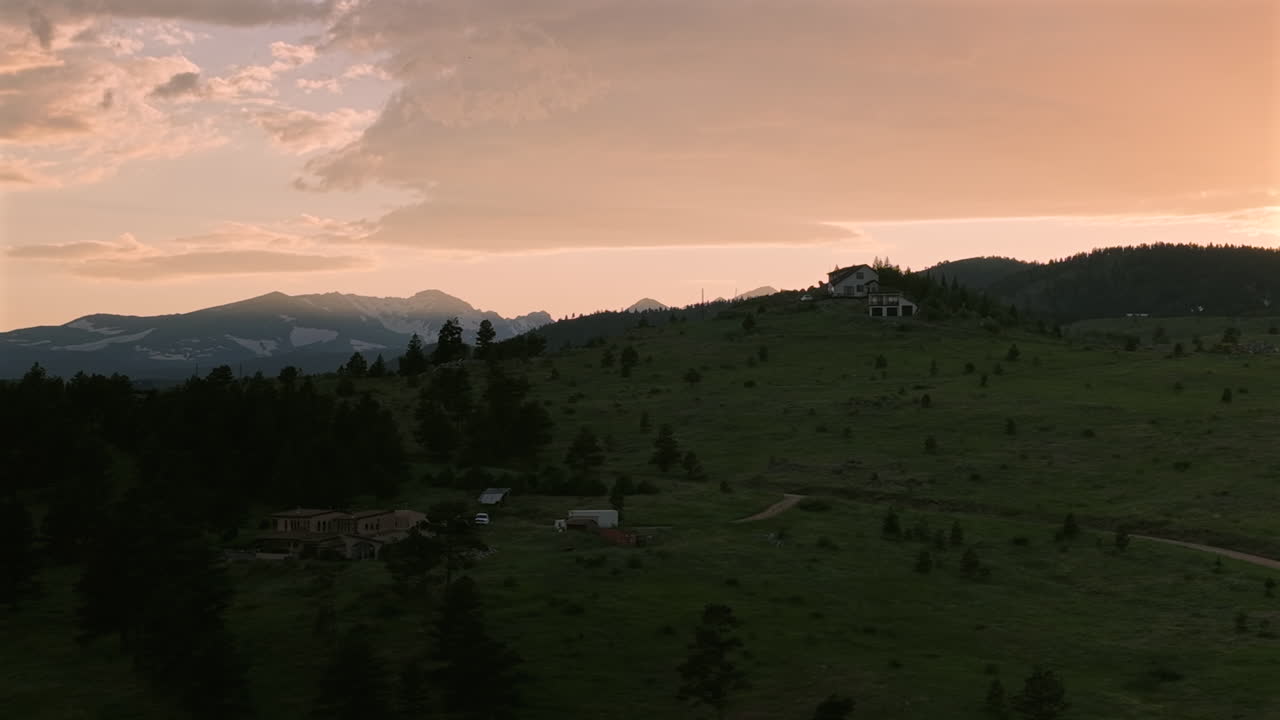 Drone footage of a summer sunset over the mountains near Boulder, Colorado. Aerial view of scenic wilderness, ridges, and forested landscapes.