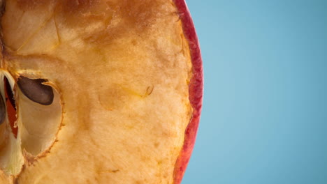 close up of half an apple on blue background