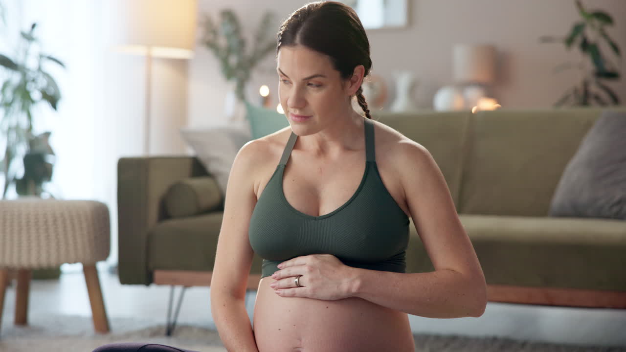 mujer embarazada haciendo yoga en casa