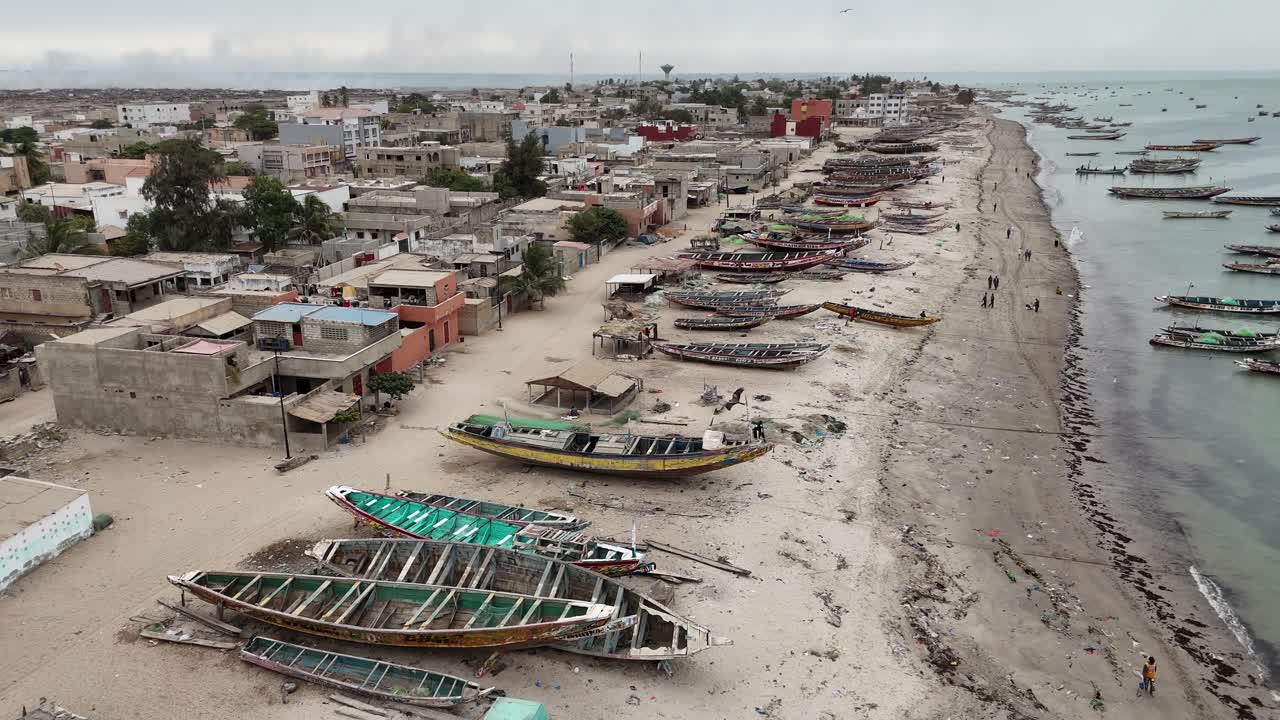 Aerial view of Joal Fadiouth fishing market, Senegal. Wooden pirogues anchored along the coastline in West African seascape