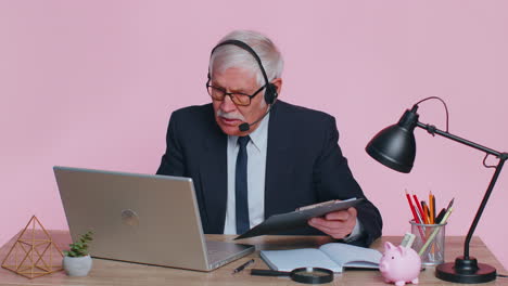 Senior-businessman-in-headphones-making-conference-video-call-on-laptop,-call-center-agent,-operator