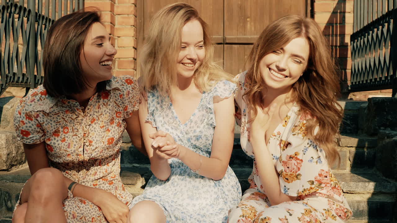 세 명의 친구들이 계단에서 웃고 있습니다.