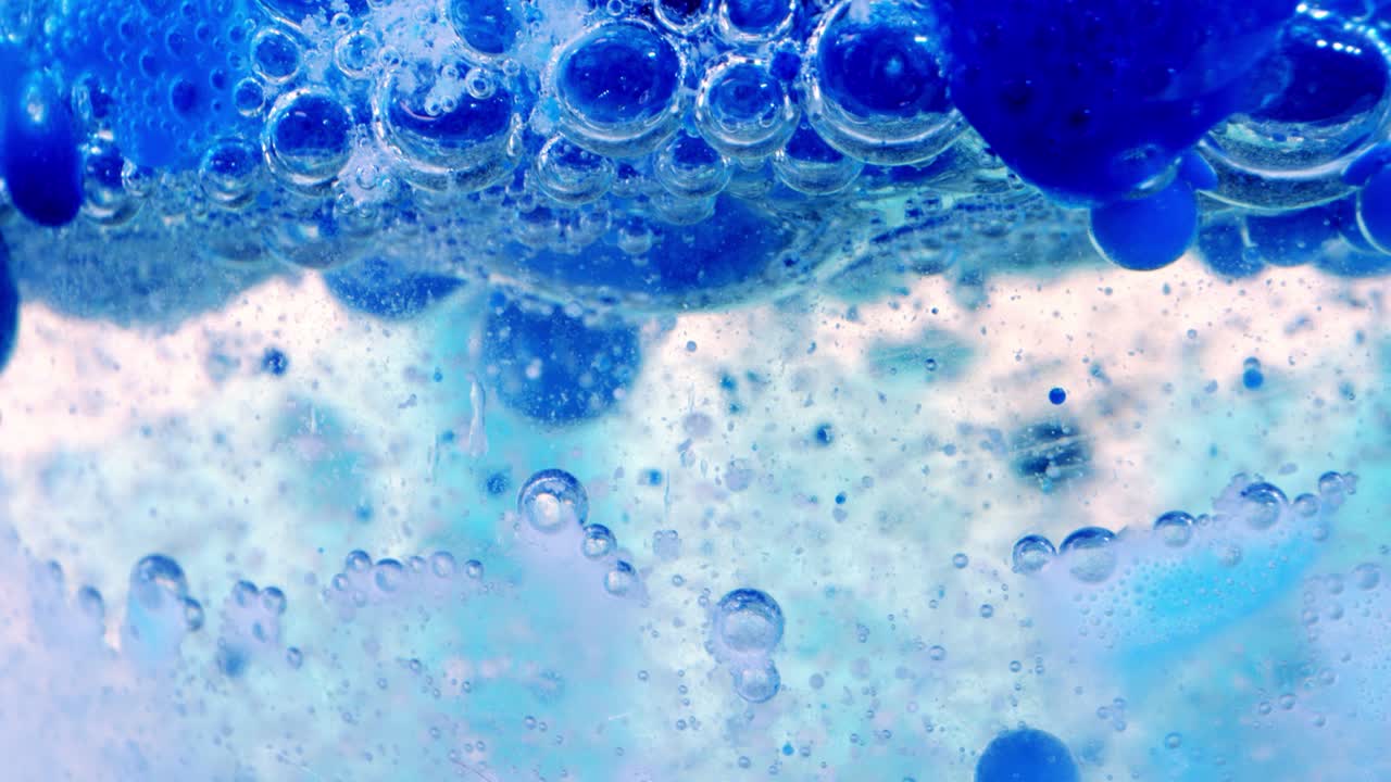 유리 뒤에 잉크가 있는 기름과 물에 있는 거품