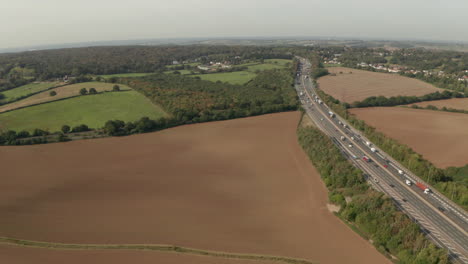 Aerial-shot-over-large-motorway-passing-through-farm-land