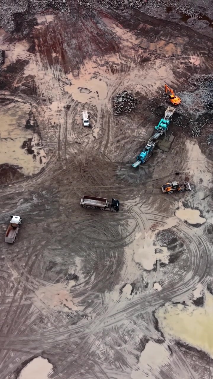 Aerial View of Heavy Machinery Working in a Muddy Quarry