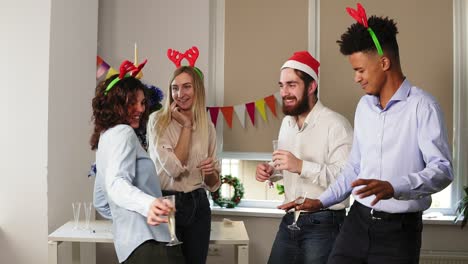 divirtiéndose durante la fiesta corporativa de año nuevo en la oficina: grupo multirracial de trabajadores de oficina felices bailando durante la fiesta corporativa