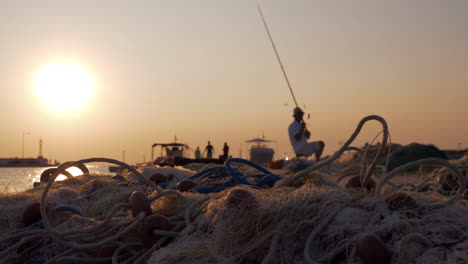 Hombre-Pescando-Desde-El-Muelle-En-El-Puerto-Al-Atardecer