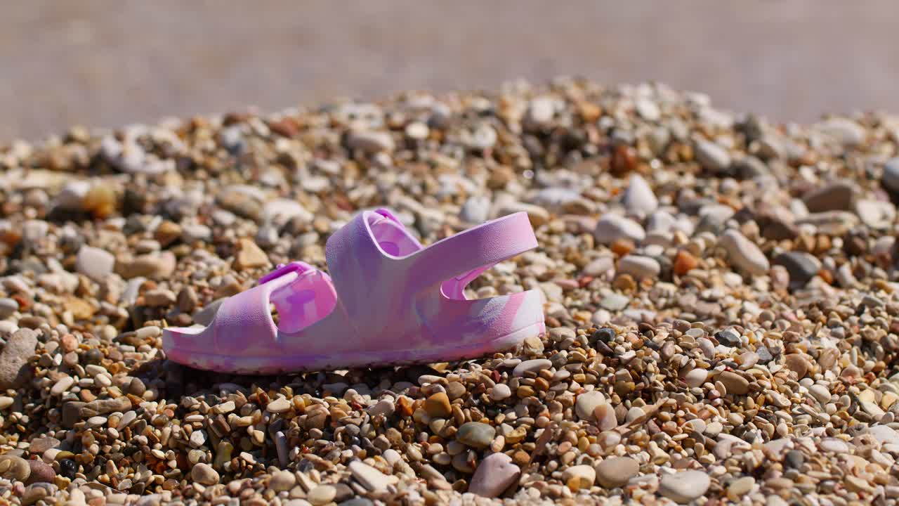 Pink sandal on Guidaloca beach, Sicilia, evokes summer and solitude