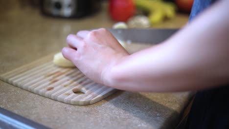 slow motion shot of someone using a knife to cut a ripe yellow banana into small slices