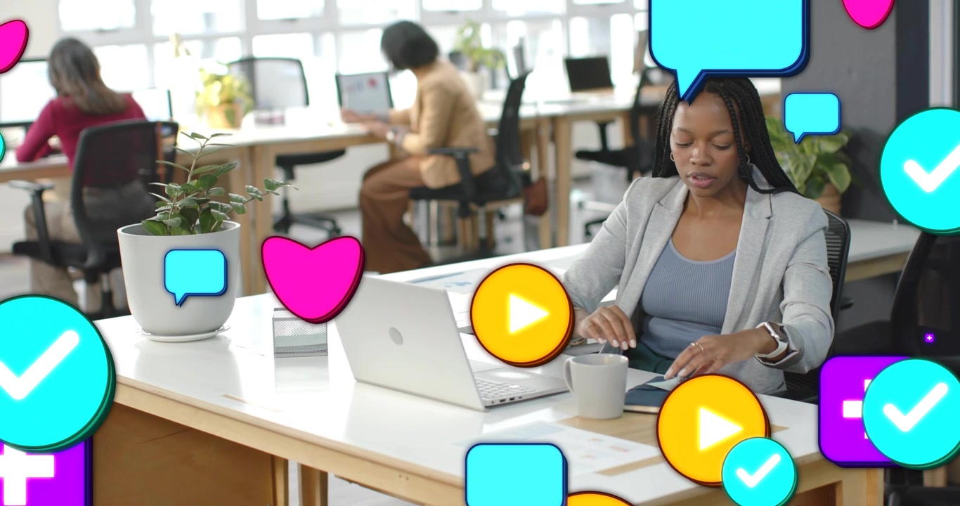 Woman at desk typing and writing while alerts spawning social icons obscuring hands for marketing