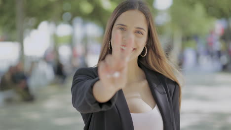 chica mostrando el signo de la victoria y sonriendo a la cámara