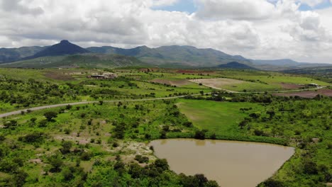 aerial shot of mountainous green landscape and highway