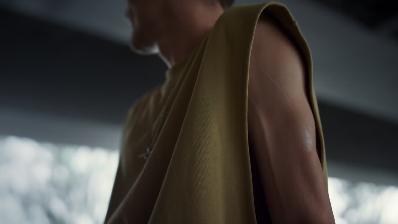 스케이트 파크에서 스케이트 보드와 함께 휴식을 취하는 젊은 남자. 멋진 스케이트 선수가 멀리보고.