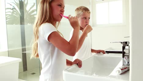 hermanos lavándose los dientes juntos