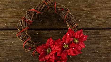 Falling-snow-with-Christmas-wreath-decoration-on-wood